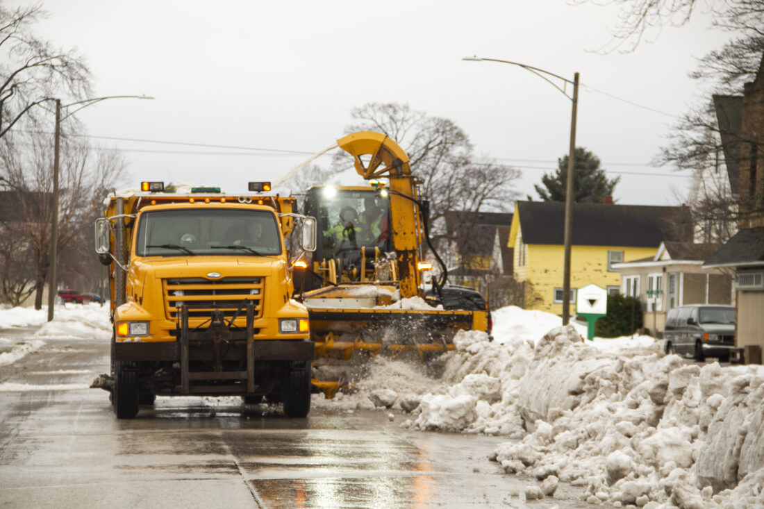 A City of Escanaba dump truck and snowblower remove snow from the middle of South 10th Street. (R. R. Branstrom | Daily Press)